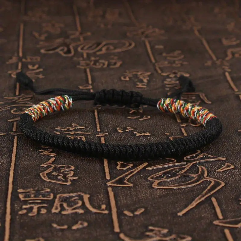 PULSERA TRENZADA BUDISTA CON DETALLE DE HILO MULTICOLOR
