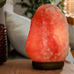 LÁMPARA DE SAL DE HIMALAYA ARTESANA NATURAL  CON BASE DE MADERA DE APOYODE  1,5 A 2 KG APROXIMADAMENTE