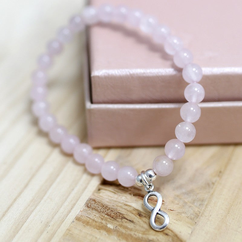 PULSERA DE CUENTAS DE CUARZO ROSA DE 6MM CON DIJES DE PLATA INFINITO